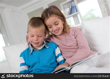 Children reading book at home