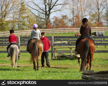 Children riding ponies and horses in a countryside
