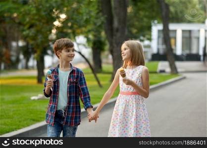 Children&rsquo;s romantic date in summer park, friendship, first love. Boy and girl eating ice cream. Kids having fun outdoors, happy childhood. Children&rsquo;s date, boy and girl eating ice cream
