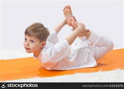 Children&rsquo;s yoga. The little boy does exercise.