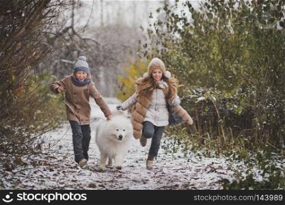 Children run the race with his beloved dog.. A boy and a girl run a race with a Samoyed 9851.