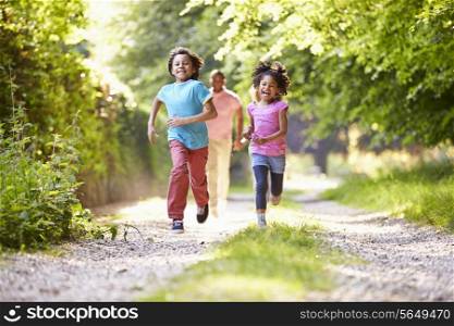 Children Running In Countryside With Father