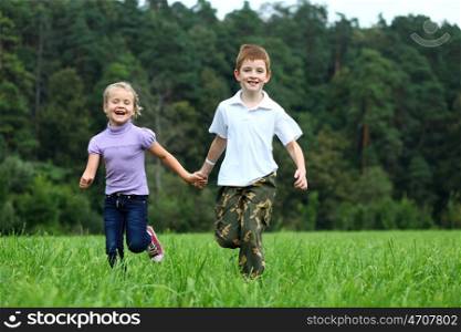 Children running on the green grass in the park