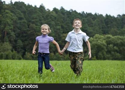 Children running on the green grass in the park