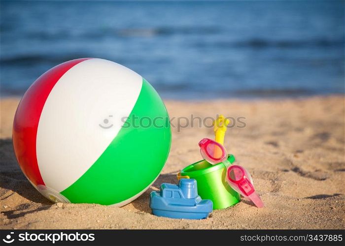 Children`s toys for sand and inflatable ball at the beach. Summer vacations concept