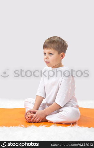 Children?s yoga. The little boy does exercise.