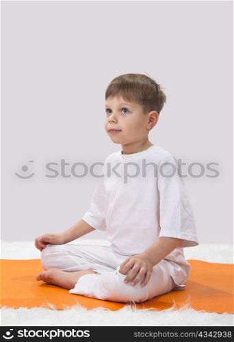 Children?s yoga. The little boy does exercise.