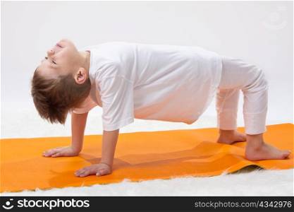 \Children?s yoga. The little boy does exercise.