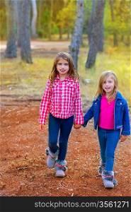 children sister girls walking at the pine forest in autumn