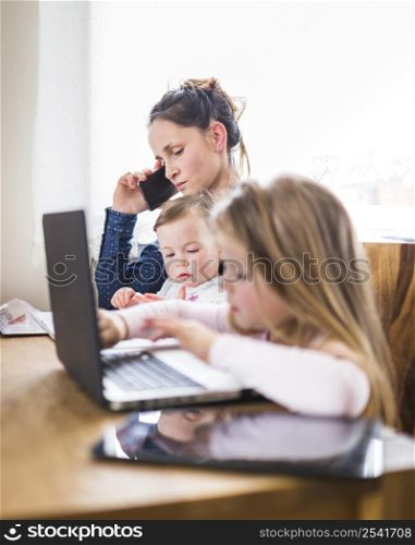 children sitting beside her mother talking mobile phone