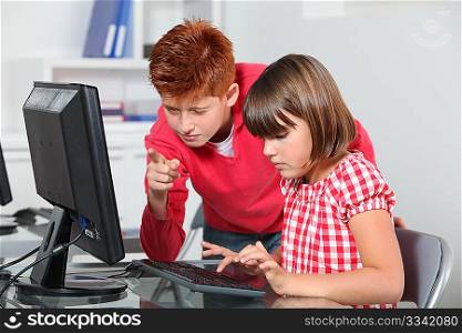 Children sitting in classroom in front of computer
