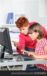 Children sitting in classroom in front of computer