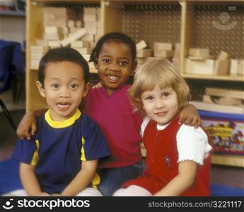 Children Sitting On Floor Of Classroom And Smiling At You