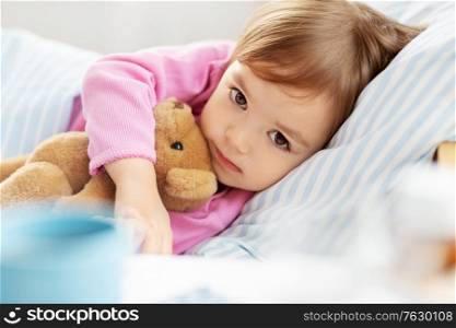 children, sleeping and people concept - little girl lying in bed at home. little girl lying in bed at home