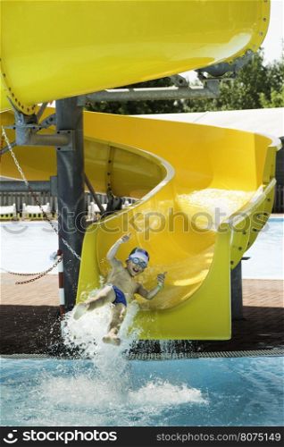 Children slide down a water slide. Sunny day