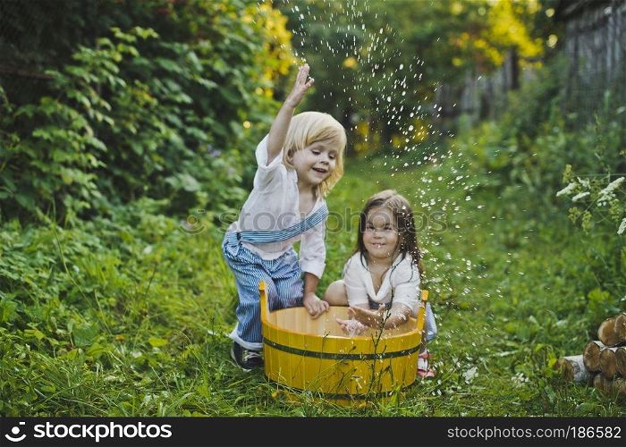 Children splashing water in the basin.. Children play with water in the garden 4752.