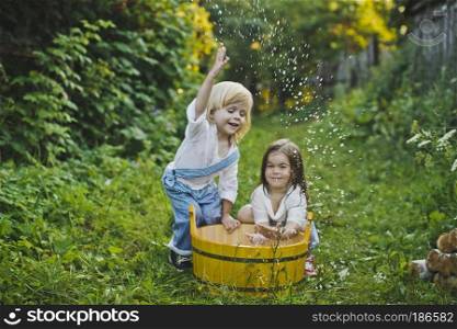 Children splashing water in the basin.. Children play with water in the garden 4752.