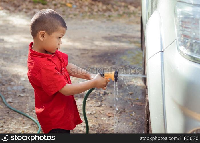 Children spray water to wash cars
