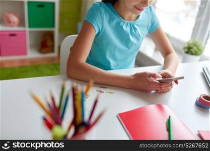children, technology and communication concept - girl with smartphone messaging at home. girl with smartphone messaging at home