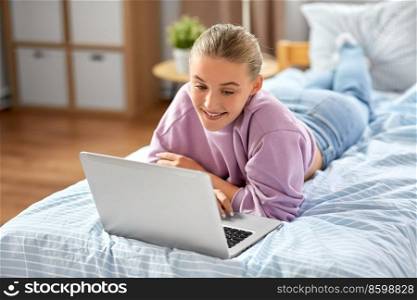 children, technology and internet concept - happy smiling student girl with laptop computer at home. smiling girl with laptop computer at home