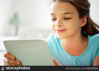 children, technology, people and communication concept - close up of smiling girl with tablet pc computer at home. close up of smiling girl with tablet pc at home