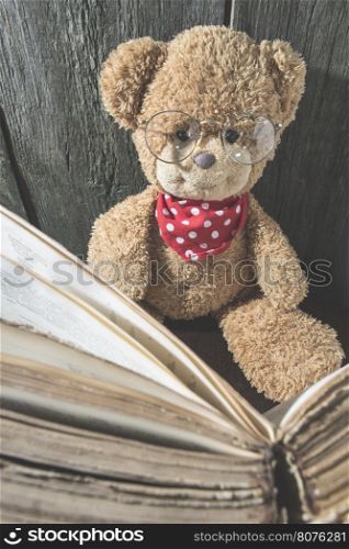 Children teddy bear with old vintage book