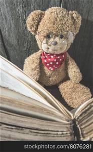 Children teddy bear with old vintage book