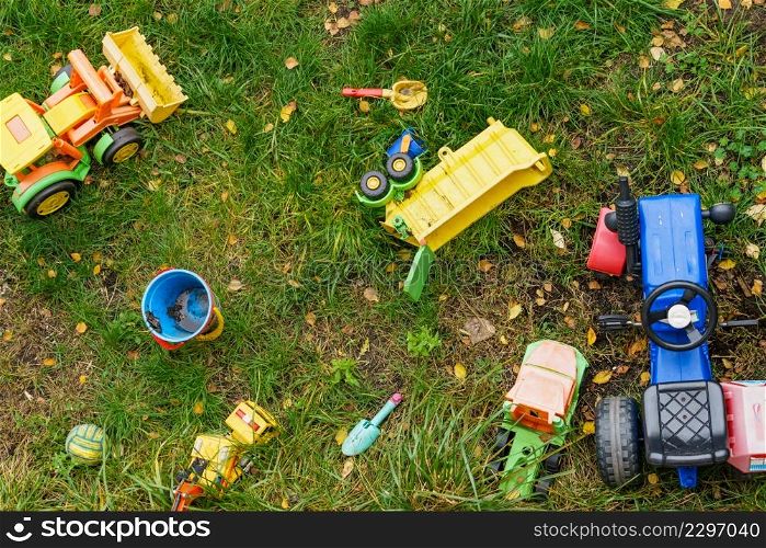 Children toys outdoors on green grass. Top view. Children toys outdoors on green grass.
