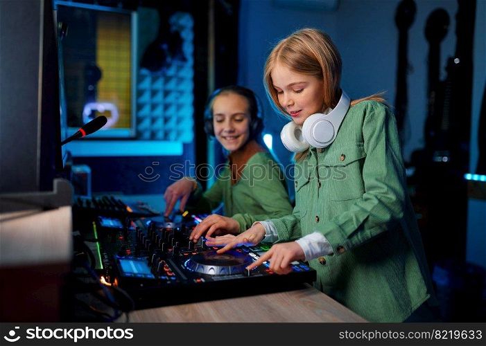 Children using sound mixer in radio station or recording studio, young preteen playing on mixing console. Children using sound mixer in radio station
