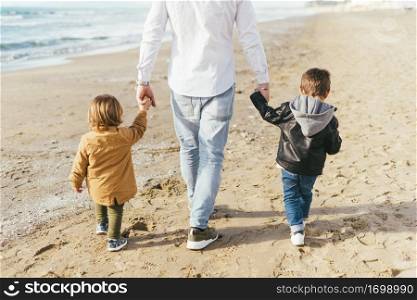 children walking beach with dad