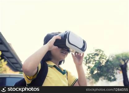 children wearing virtual reality glasses with fun and surprising face standing outdoor