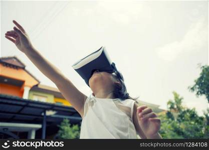 children wearing virtual reality glasses with fun and surprising face standing outdoor