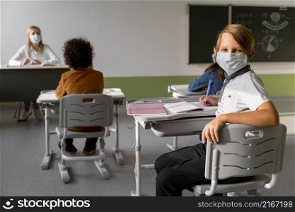 children with medical masks learning school with female teacher