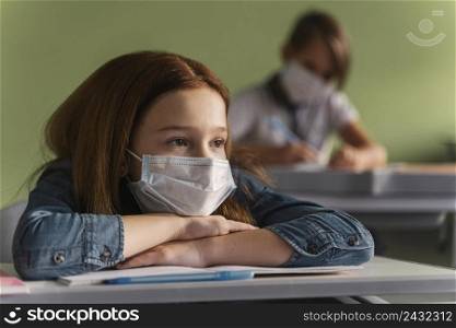 children with medical masks listening teacher class