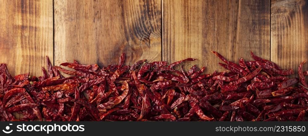 Chile de Arbol on wooden background. This potent Mexican chili can be used fresh, powdered or dried in a variety of Mexican dishes. panoramic top view