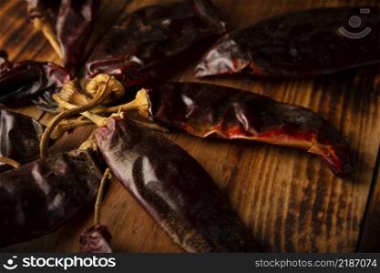Chile Guajillo. This Mexican chili is the dried form of mirasol chili and are used in a variety of Mexican preparations. Rustic wooden board. Close up