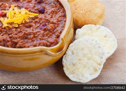 Chili Con Carne topped with shredded cheddar cheese, and served with hot buttered biscuits.