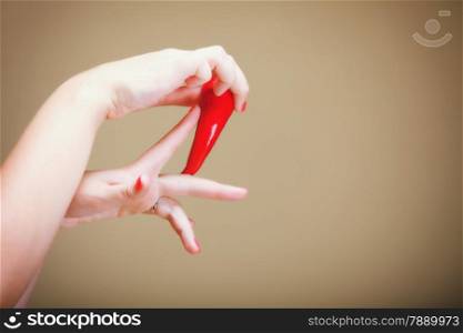 chili pepper in female hand brown background