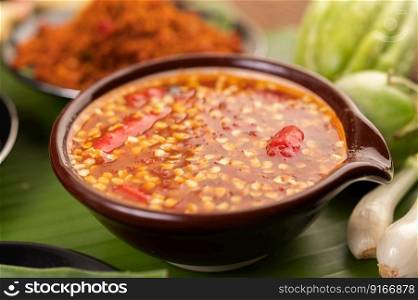 Chili sauce and ingredients placed on banana leaves.
