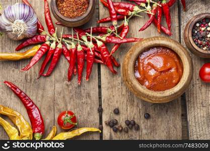 Chili sauce on wood background.Spicy sauce for meat food. Spicy chili sauce or ketchup