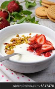 Chilled Buttermilk soup from Greek yogurt with strawberries and pistachios, cashews. Serve with crispy biscuits. Vertical shot.. Chilled Buttermilk soup