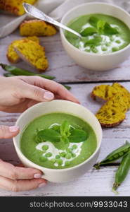 Chilled soup puree of green peas,  seasoned with green onion, mint and crunchy  toasted diced rusk bread  