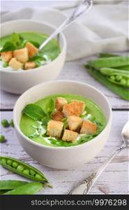 Chilled soup puree of green peas,  seasoned with green onion, mint and crunchy  toasted diced rusk bread  