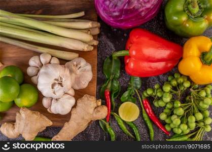 Chilli, lime, basil, kaffir lime leaves, eggplant, ginger, spring onions, bell peppers, garlic, lemongrass, put together for cooking.