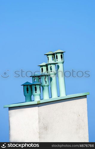 chimneys on a roof with a blue sky