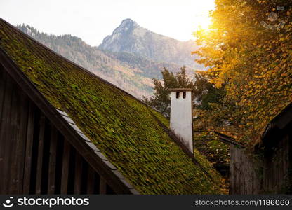 chimneys on a wooden house with a tiled roof and mountains in the background