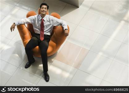 Chinese businessman relaxing in an armchair