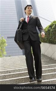 Chinese Businessman Walking Down Steps Carrying Bag Outside Office