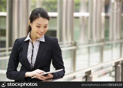 Chinese Businesswoman Working On Tablet Computer Outside Office
