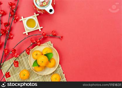 Chinese character means fortune and luck.Top view of Lunar New Year & Chinese New Year vacation concept background.Flat lay cup of tea with red pocket money and pink cherry flower on red paper.